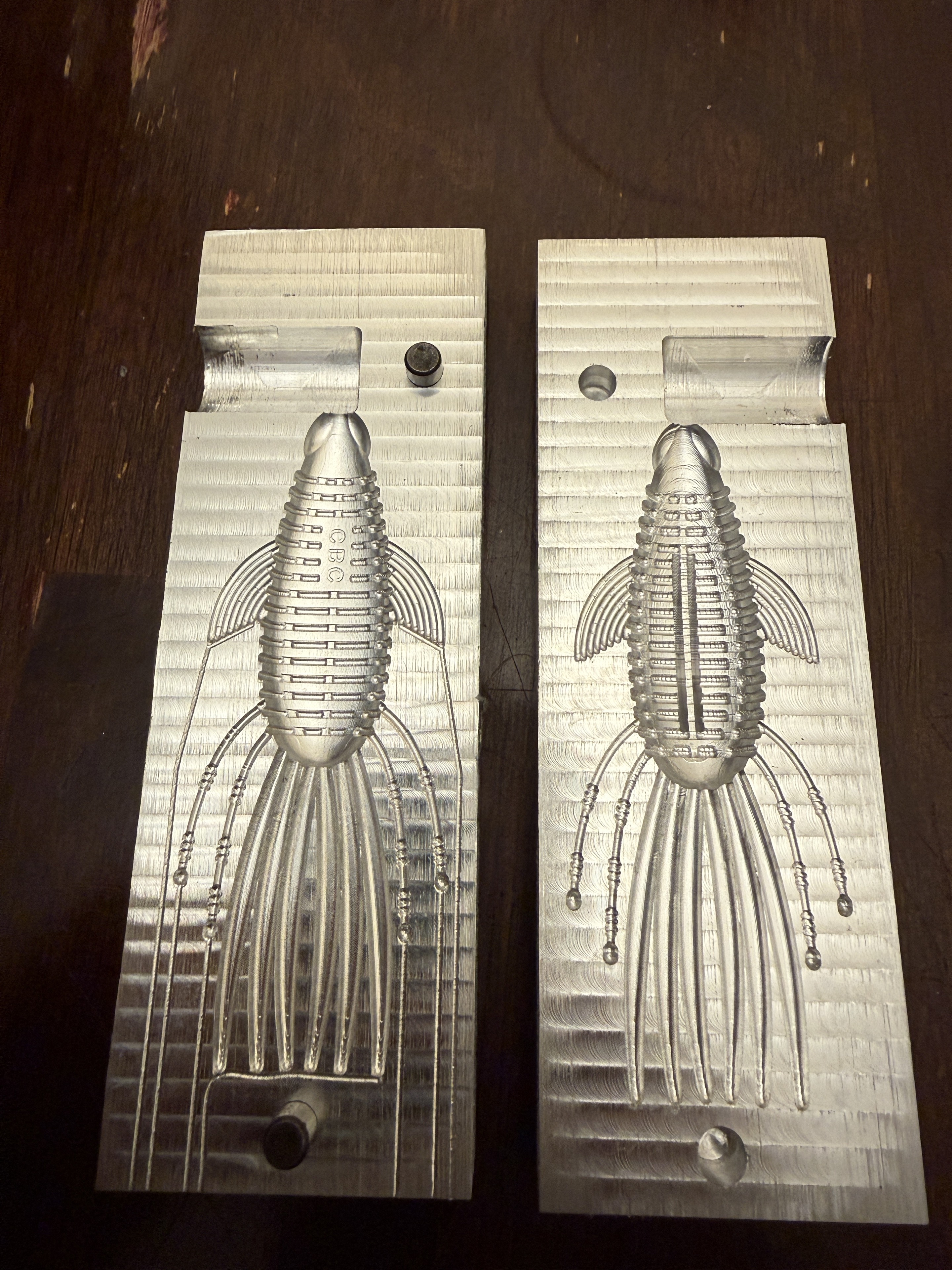 Two open aluminum Pad Bug mold halves showing the bait cavities