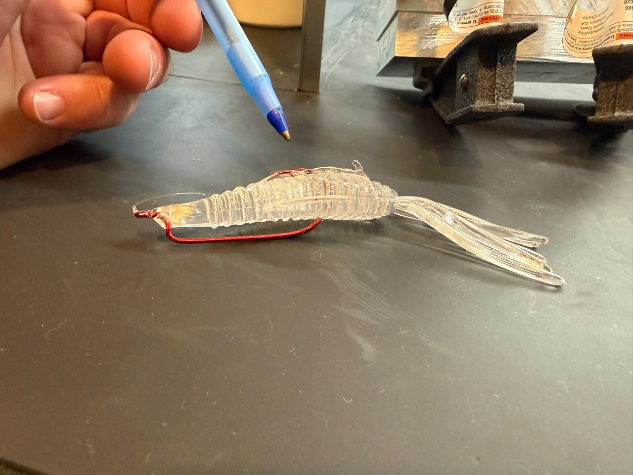 Clear Pad Bug prototype rigged on a red hook on the CBC workbench